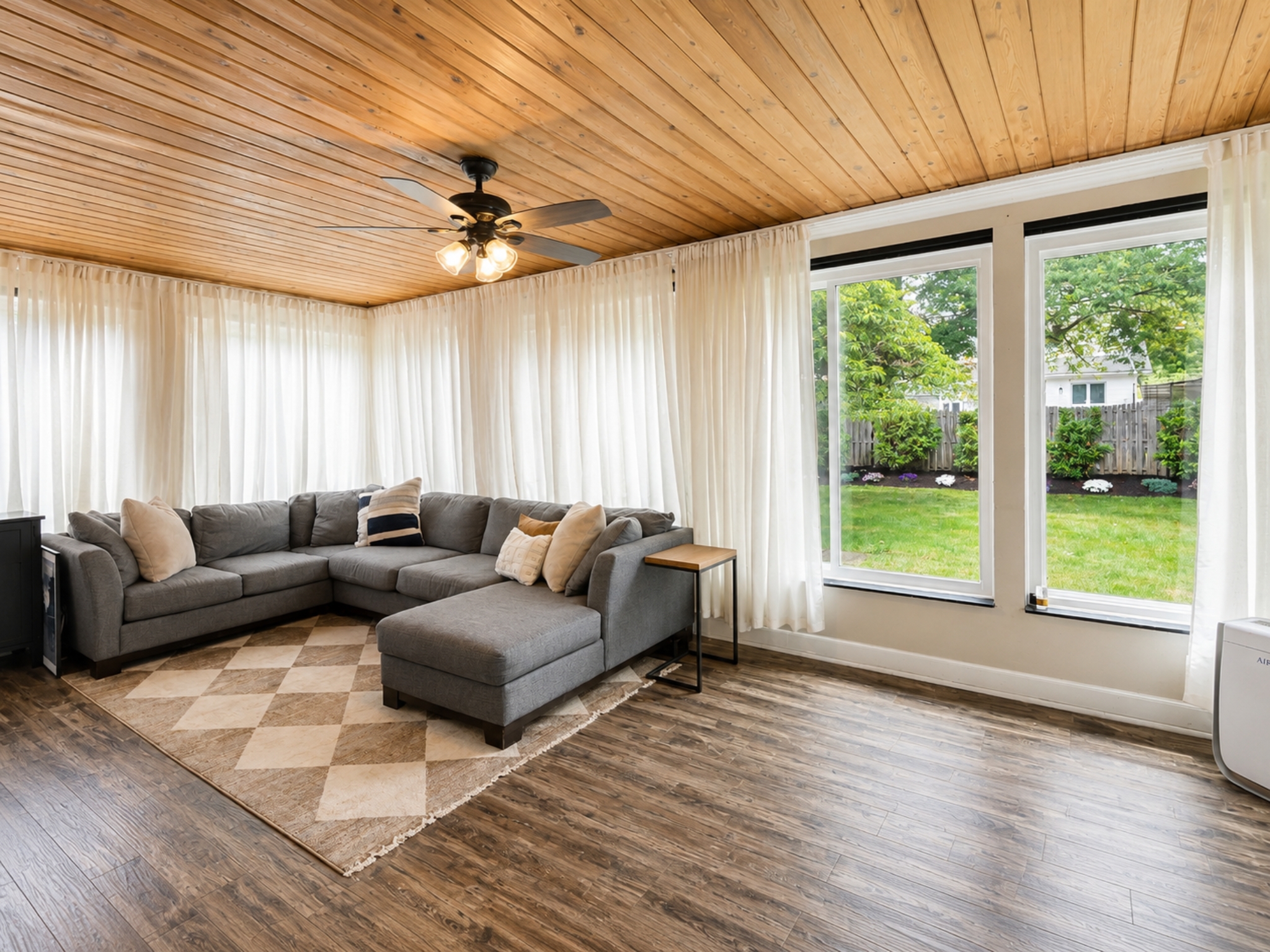 Sunroom with wood ceiling and garden views